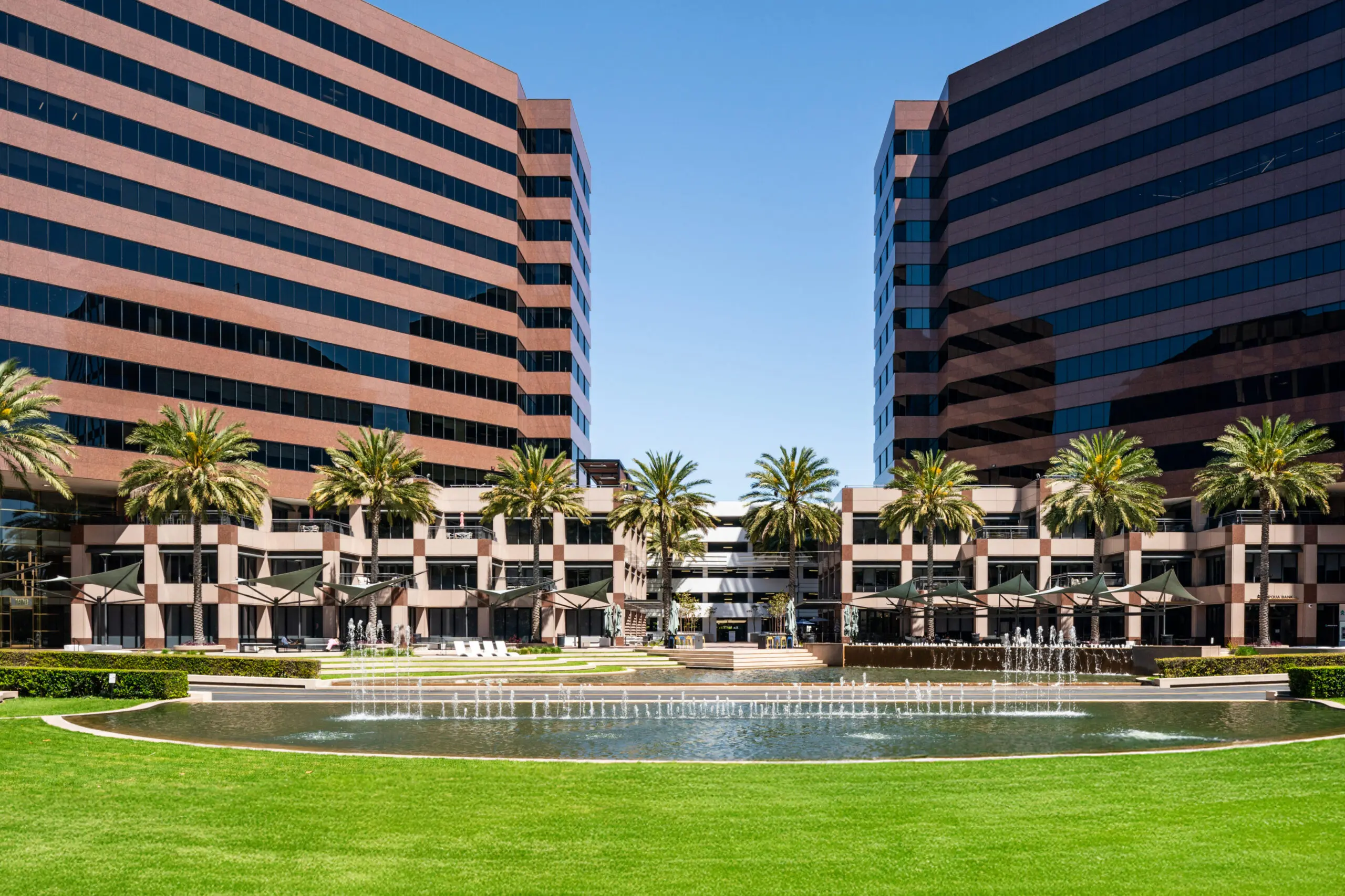 Office towers with palm trees, a lawn and a fountain